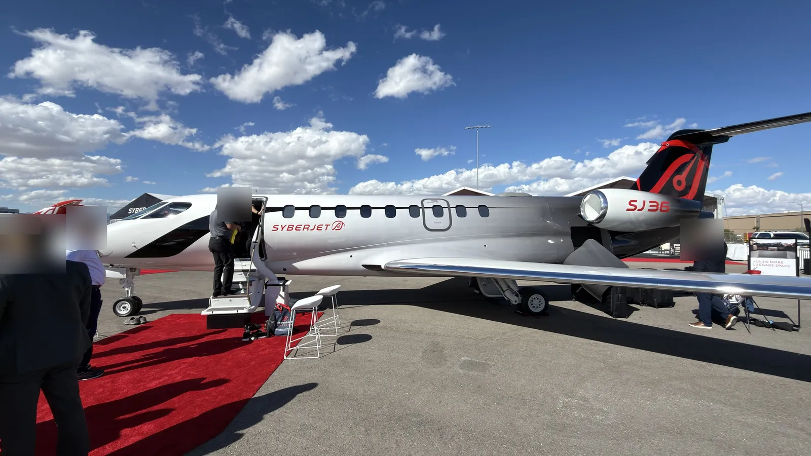 SyberJet SJ36 mockup at the NBAA static display in Henderson, with a red carpet at the airstair and visitors around it